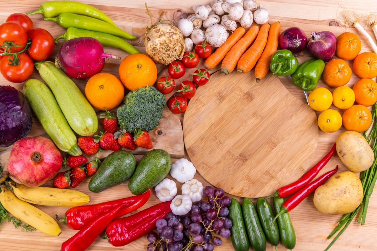 foods for gut healing including yogurt, sauerkraut, oats, bananas, and ginger on a wooden table
